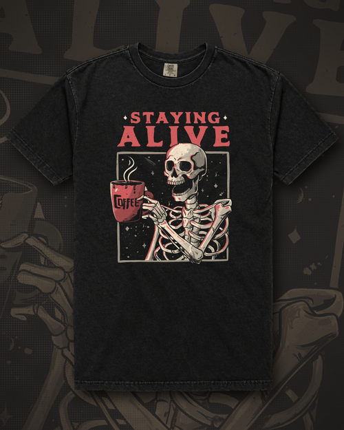 Skeleton holding a large red mug labelled Coffee inside a rectangular frame under the words Staying Alive graphic on black t-shirt – Staying Alive Tee by CREEPTEE