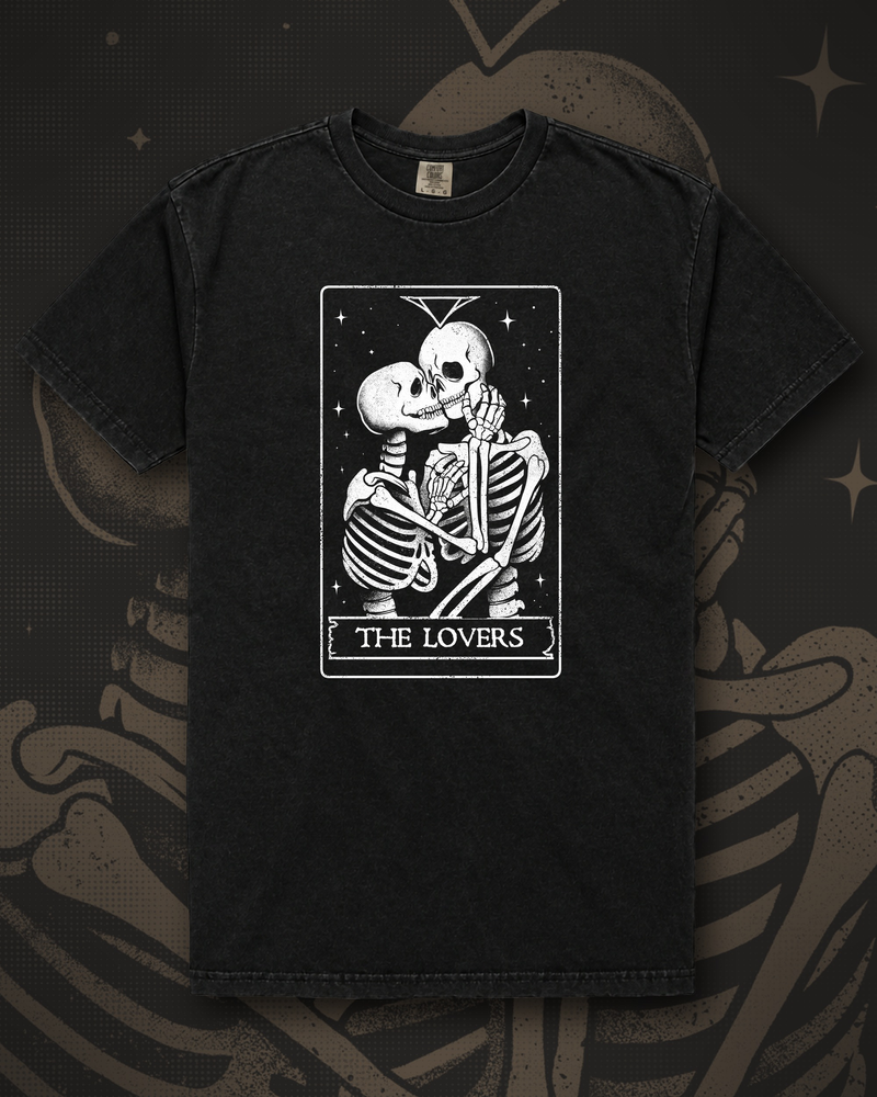 Line-art tarot card of two skeletons kissing under a starry sky, titled The Lovers graphic on black t-shirt – The Lovers Tee by CREEPTEE